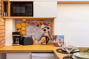 A compact kitchen with modern appliances, stylish wooden accents, and a welcoming dining setup.
