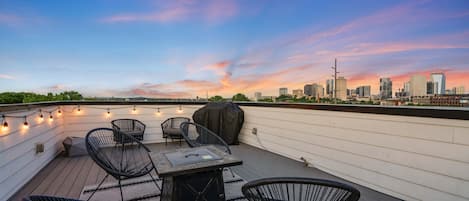 The rooftop lounge is outfitted with cozy patio furniture, gas fire pit and grill, and epic views of the Nashville skyline