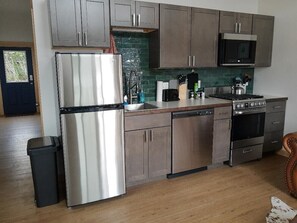 Lupine Cabin – Kitchen Equipped with Fridge, Dishwasher, 12-Cup Drip Coffee Maker, Toaster, Microwave, 4-burner stove with Oven, Tea Kettle, Coffee, Creamer, Sugar, Tea, Filters, and Basic Cooking Essentials.
