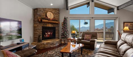 Comfy living room with TV, fireplace, sofa, and 2 arm chairs.