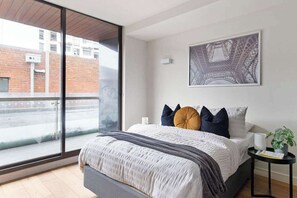 A MASTER bedroom with a queen sized bed & plush pillows.
