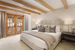 Primary bedroom with king size bed, private balcony and en-suite full bathroom