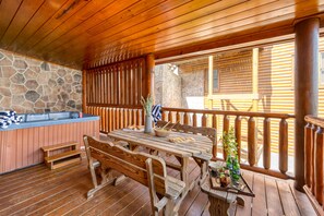 Bottom level deck features a picnic table and hot tub.