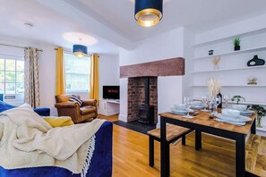 The living room is equipped with a sofa bed, 40-inch Smart TV with Netflix, and a dining area for up to 4 guests.