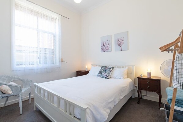 A bright bedroom with a queen-size bed and comfy linen is the best place to wake up in, ready for the day ahead