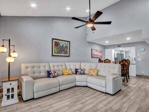 Living room with leather reclining power couch, fans and Roku TV