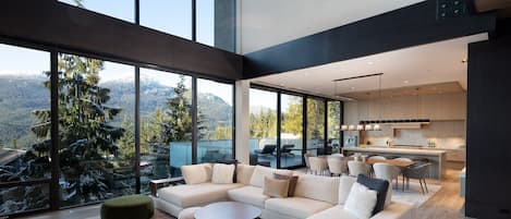 Open-plan living area with a vaulted ceiling and breathtaking views through floor-to-ceiling windows