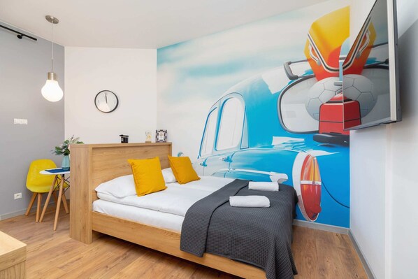 A vibrant bedroom with colorful wall art, a comfortable bed, and modern furnishings, perfect for relaxation.
