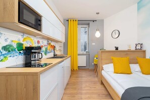 A fully equipped kitchen with white cabinetry, a colorful backsplash, and modern appliances for convenience.
