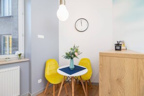 A dining area with a round table, yellow chairs, and a wooden cabinet, creating a cozy and functional space.
