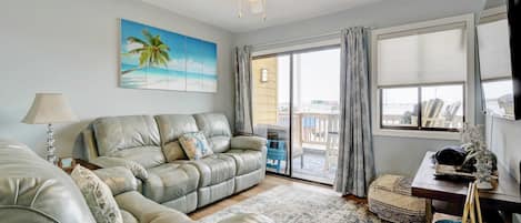 Timeless comfort awaits in this naturally lit living room adorned with a classic-style sofa.