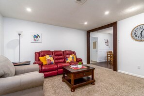 Family room with comfy sectional and overstuffed recliner with charging port.