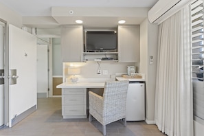 View of desk area w/ TV from bed area.