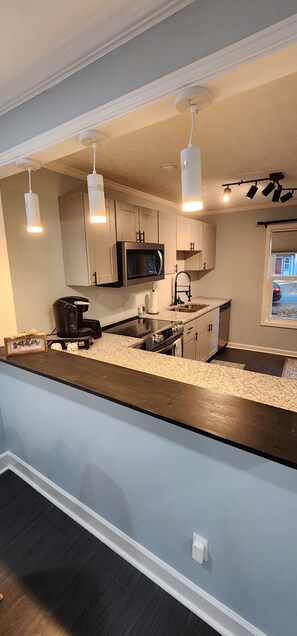 Full sized kitchen with major appliances, stocked with dishes and essentials.