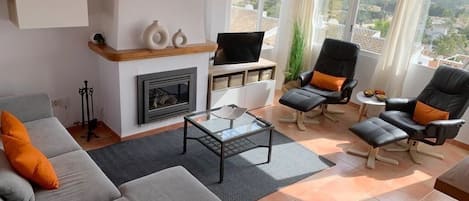 Spacious living room with TV, fire place and airconditioning