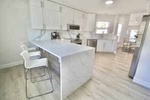 Jupiter Sunshine’s gorgeous white marbled quartz island counter with bar seating for 3. Plenty of island outlets for charging devices.