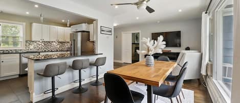 Open concept kitchen and dining area, with seating for 6 at the table, and additional 3 guests at the bar. 