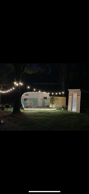 SHASTA Camper & outhouse . The outhouse has a compost toilet and bathroom sink.
