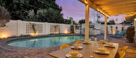 Private backyard with an outdoor pool and an outdoor dining area