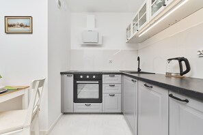 A compact kitchen with white cabinets, modern appliances, and a clean, functional design.
