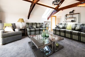 Roundhill Coach House - the inviting lounge with sumptuous seating and feature beams