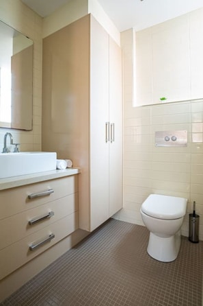 Bathroom with toilet, soft towels, starter kit of toiletries and hairdryer for guests' use.