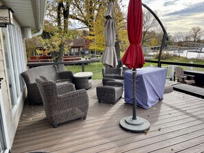 DECK FEATURES A 6 PERSON DINING TABLE AND SHADE UMBRELLAS