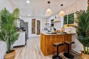 The spacious kitchen has an island with seating for 2, stainless appliances, and is fully stocked.
