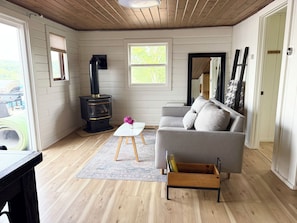 The small, comfortable living room has a fireplace and leads out onto the deck.