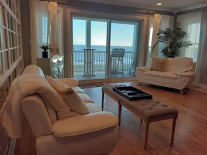 First living room area with a waterfront  balcony overlooking the beach.   Gorgeous sunset and sunrise views. 