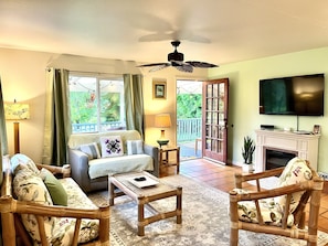 tropical living room with fireplace and smart tv and twin pull out sofa bed