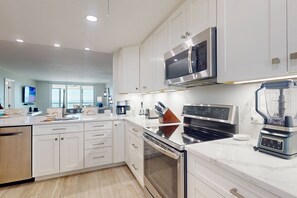 Fully Equipped Kitchen With Quartz Countertops and Stainless Appliances