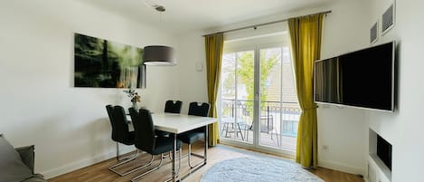 Wohnbereich mit Sofa, Esstisch und Bestuhlung