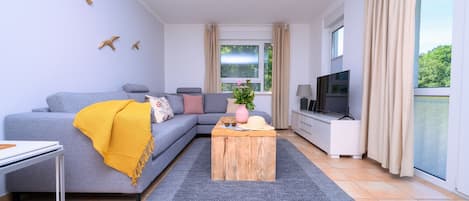 Wohnzimmer mit Sofa, Sideboard und TV