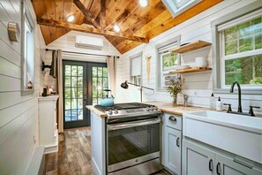 Our open concept main floor. The kitchen has a full-size gas range and oven, farmhouse sink, fridge, and all the cookware you'll need to make your favorite meal.