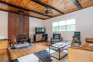 Our main room, complete with wood stove, smart TV,  Poly & Bark leather sofa, record player, and curated amenities throughout