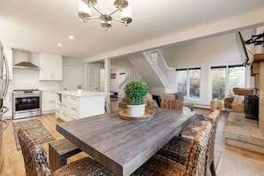 The open-air floorplan of the home's main level is  a great space to gather after a day of adventuring in the mountains!  The dining table seats 6 with additional seating available for 3 more at the kitchen island.