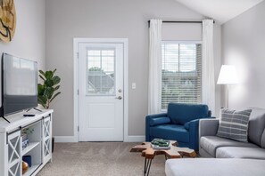 Beautiful cozy living room with plenty of comfortable seating and designer decor. Pond view from windows. :)