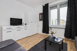 Another view of the living room, showcasing the TV setup and modern furnishings.
