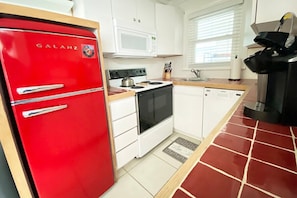 The retro red kitchen is fully stocked with all the supplies you will need if you want a home cooked meal- including a variety of baking dishes, pots and pans, measuring cups, plates, glasses, wine glasses, etc.