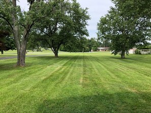 Front porch overlooks large yard with mature shade trees. Large back yard is fenced for pets.