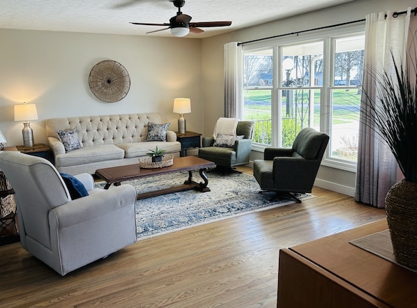 Natural light floods this beautiful LR area with 3 swivel chairs -- perfect for conversation or watching a movie.