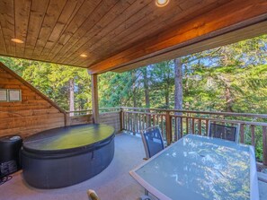 Back patio featuring the hot tub, seating area, and views.