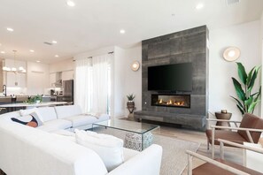 Living room featuring a sectional sofa, fireplace, and large 75"' LG TV