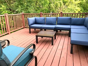 Loft bedroom deck with comfortable furniture accessed through patio doors 