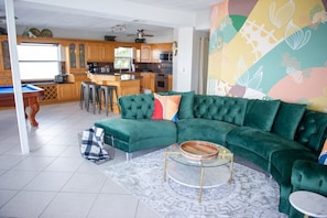 We were so excited about getting this retro green velour couch to match style and vibe of this beachy boho waterfront home. It is so comfortable, too! The living room is set up perfectly for spacious lounging- as well and dolphin watching over the intracoastal!
There is a 32 inch TV with Roku in the living room.