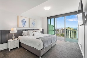 Upstairs, the main bedroom offers a king bed, TV, ensuite bathroom with a bathtub, walk-in shower, double vanity, toilet, and a walk-in robe.