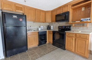 The unit features a kitchen that is larger than most 1-bedroom units with additional cabinet space and extra countertops.