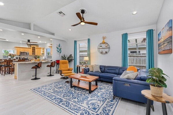 Bright and spacious living room with comfortable seating and a 65" Roku TV