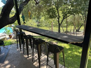 Outdoor bar area is conveniently located by propane grill, pool and back patio. 